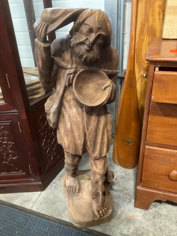 Carved wood sculpture of bearded traveler with dog