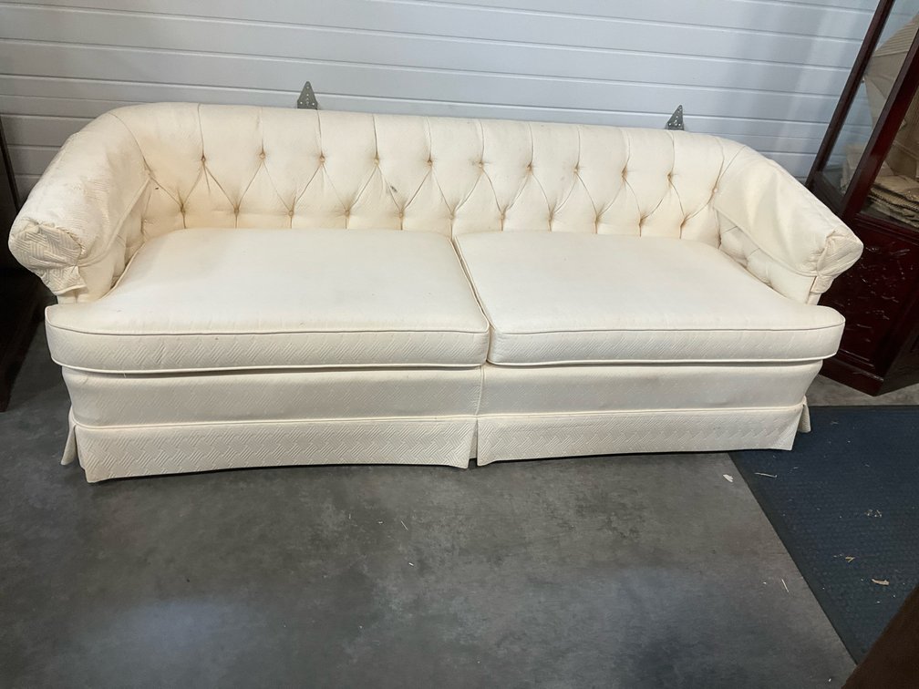 Cream tufted roll-arm sofa with pleated skirt