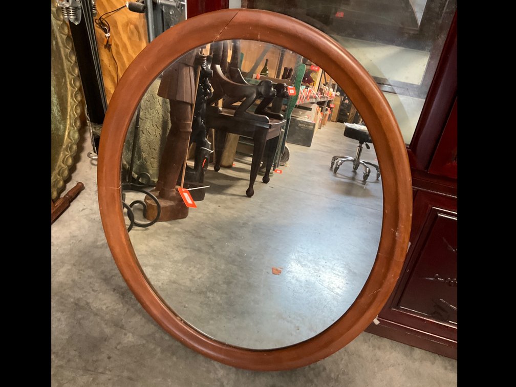 Oval wood-framed mirror in reddish-brown finish