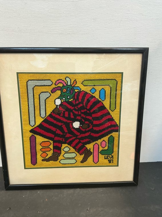 Framed needlepoint art of striped figure