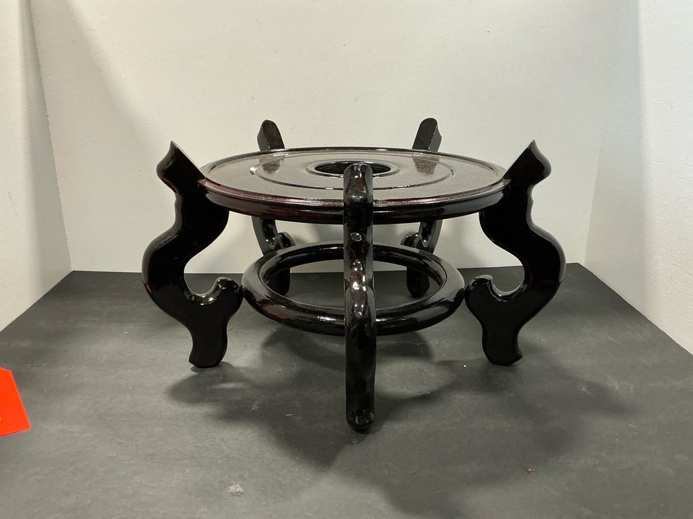 Dark lacquered carved wood circular display stand