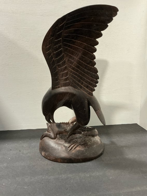 Carved dark wood eagle sculpture with raised wings