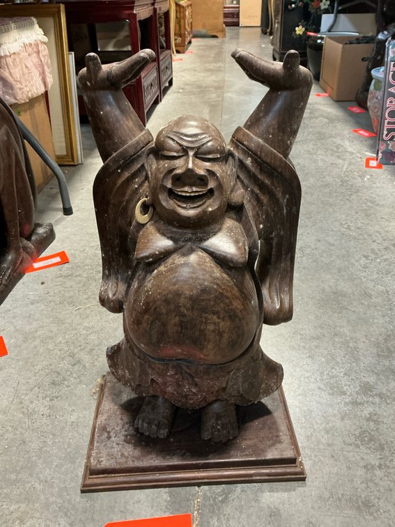 Carved wood laughing Buddha statue on plinth