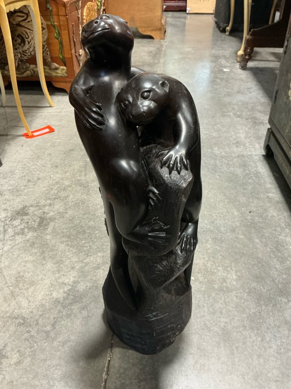 Carved dark wood sculpture of two otters