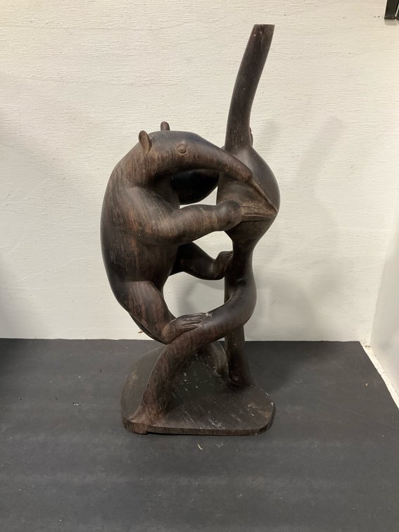 Carved dark wood climbing anteater sculpture