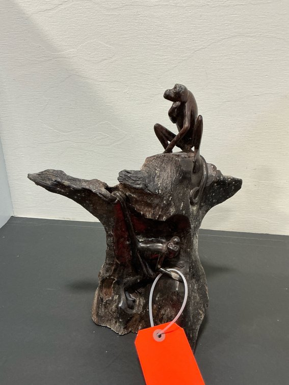 Carved dark wood monkey tree trunk sculpture