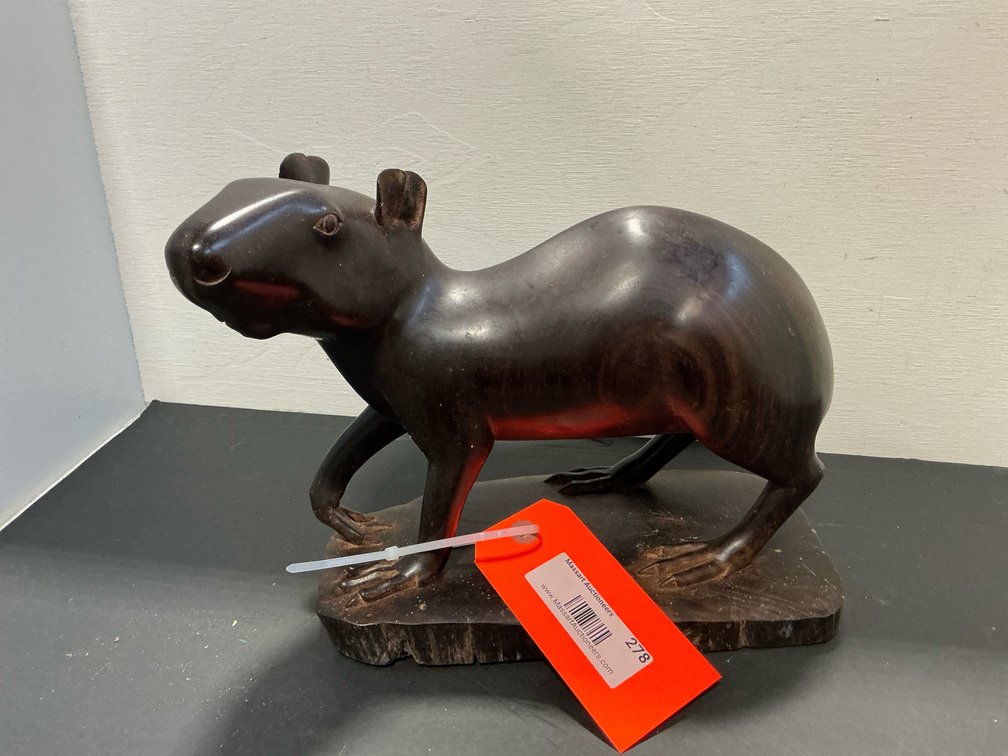 Carved dark wood rodent sculpture on slab base