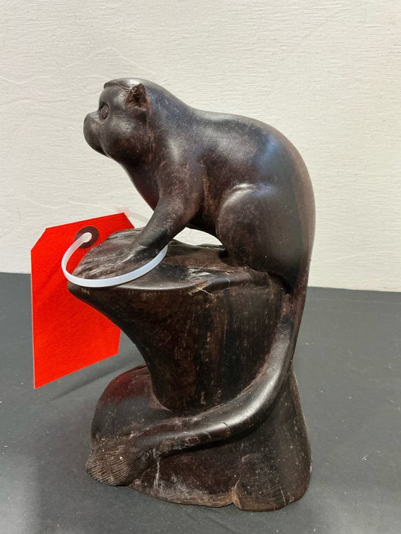 Carved dark wood animal figure on rock base