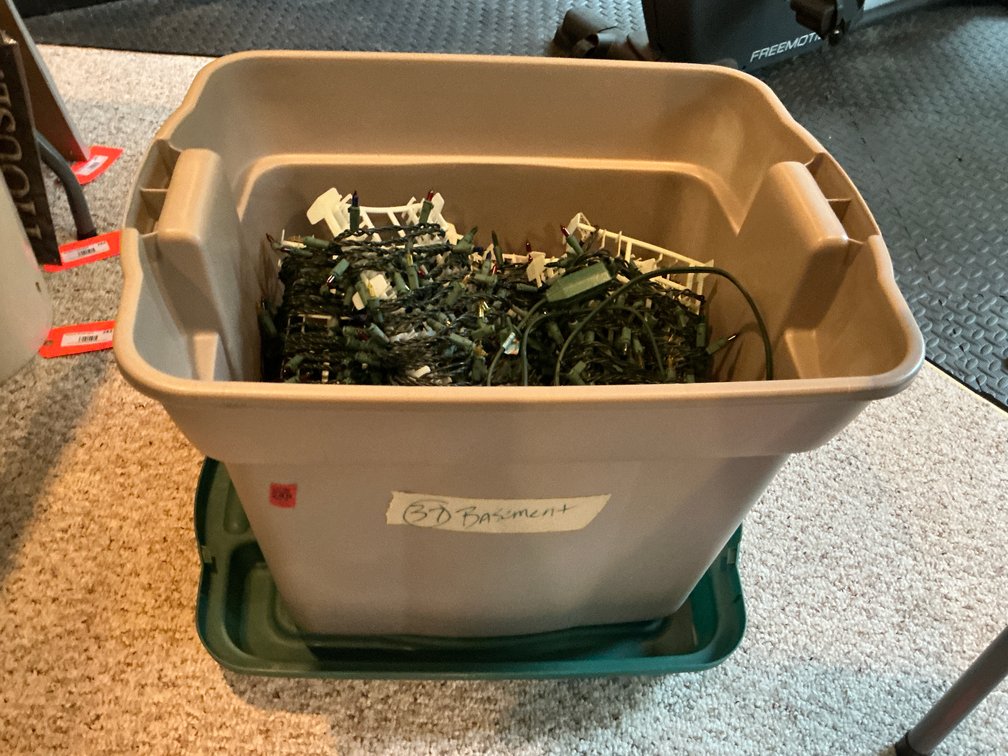 Multicolor Christmas lights on spools in storage tote - Basement