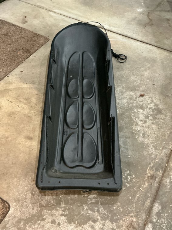 Black molded plastic utility sled with pull rope - Garage