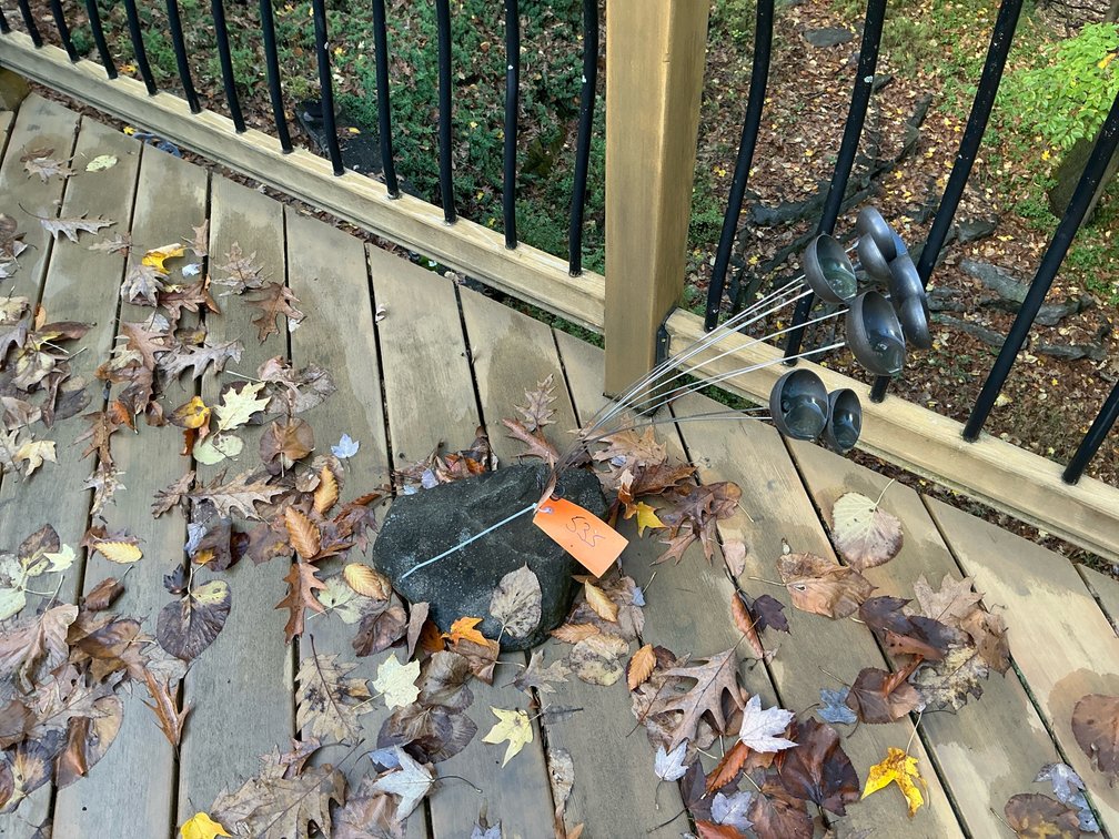 Metal kinetic bell sculpture on natural stone base - Deck