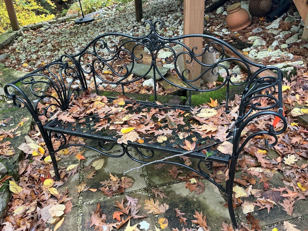 Black metal garden bench with scrollwork & lattice seat - Outside