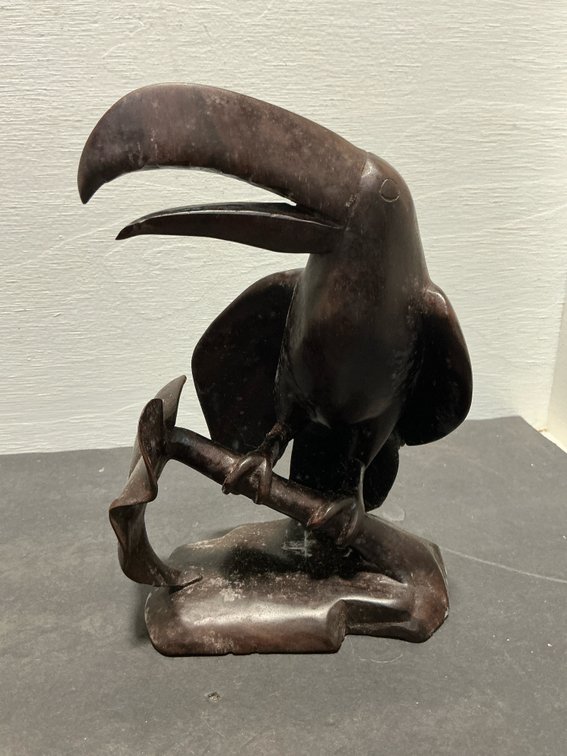 Carved dark wood toucan figurine on branch base