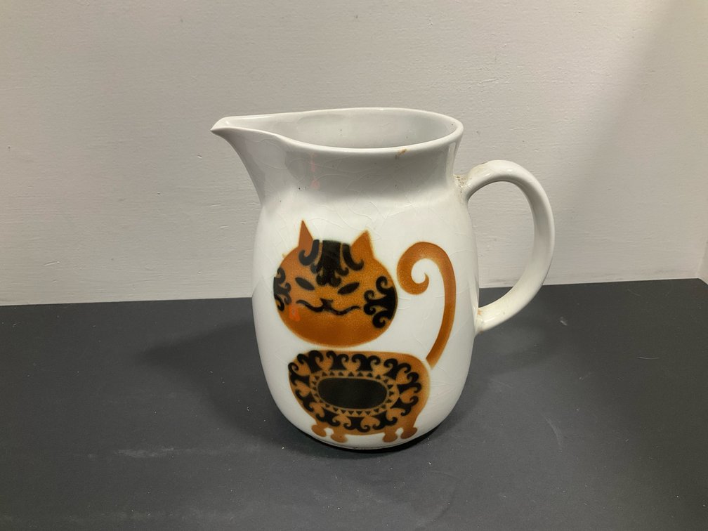 White ceramic pitcher with stylized cat