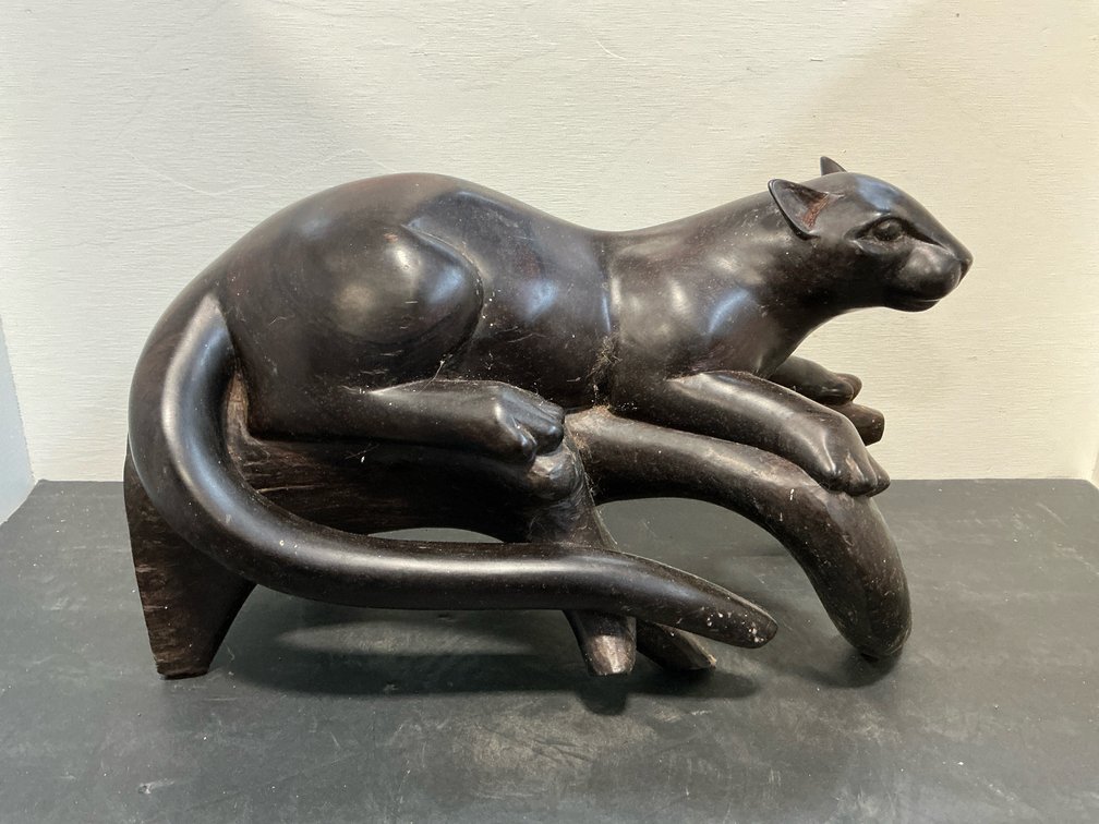 Carved dark wood panther on branch sculpture
