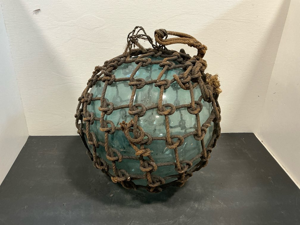 Aqua glass fishing float in knotted rope netting