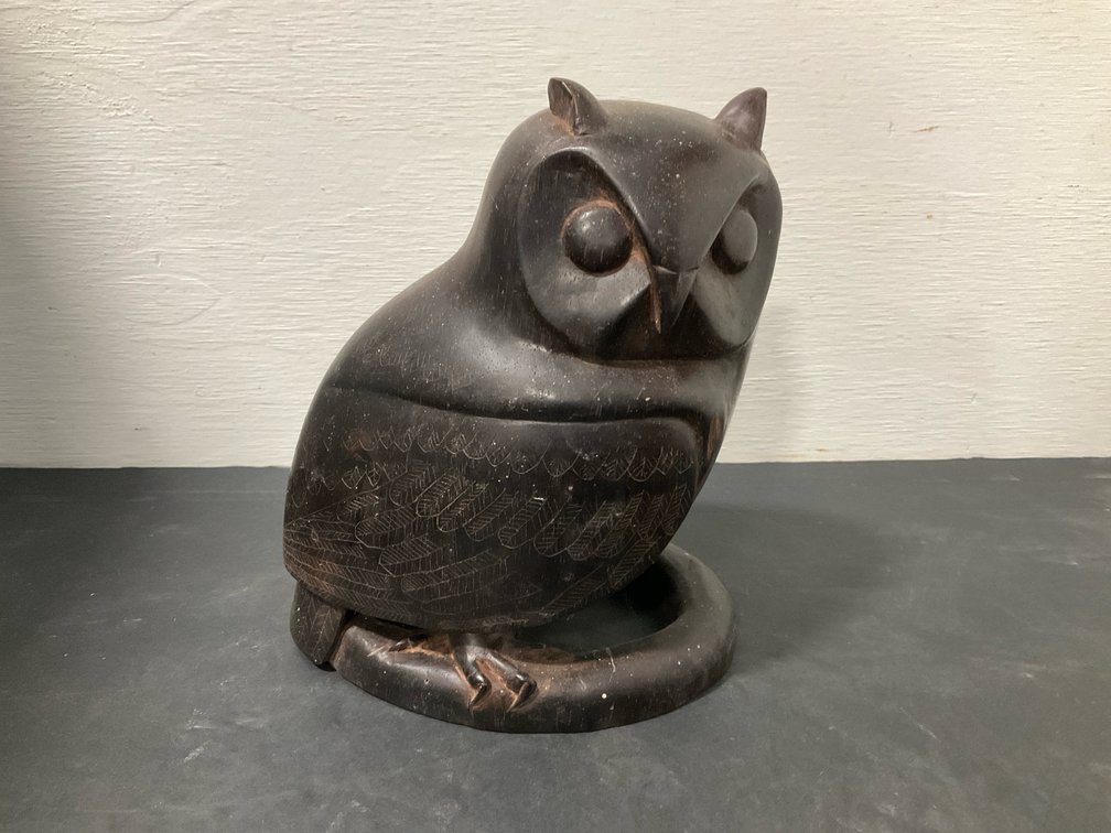 Carved dark wood owl figurine on curved base