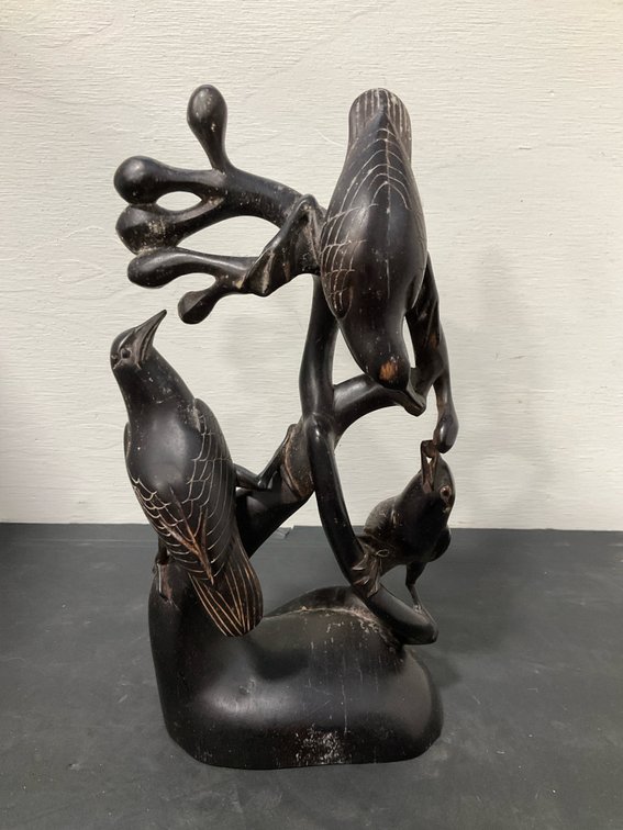 Carved dark wood sculpture with three birds