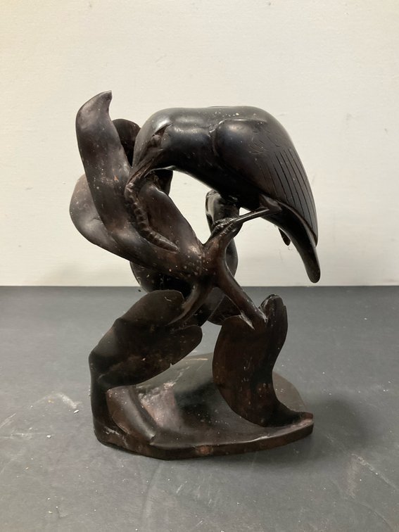 Carved dark wood bird and foliage sculpture