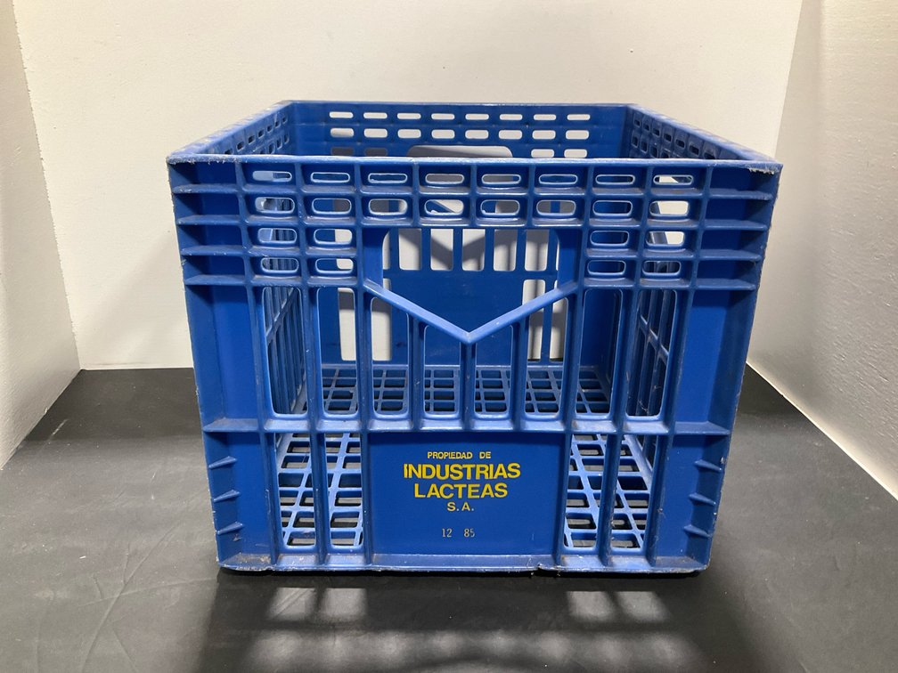 Blue molded plastic milk crate with handles