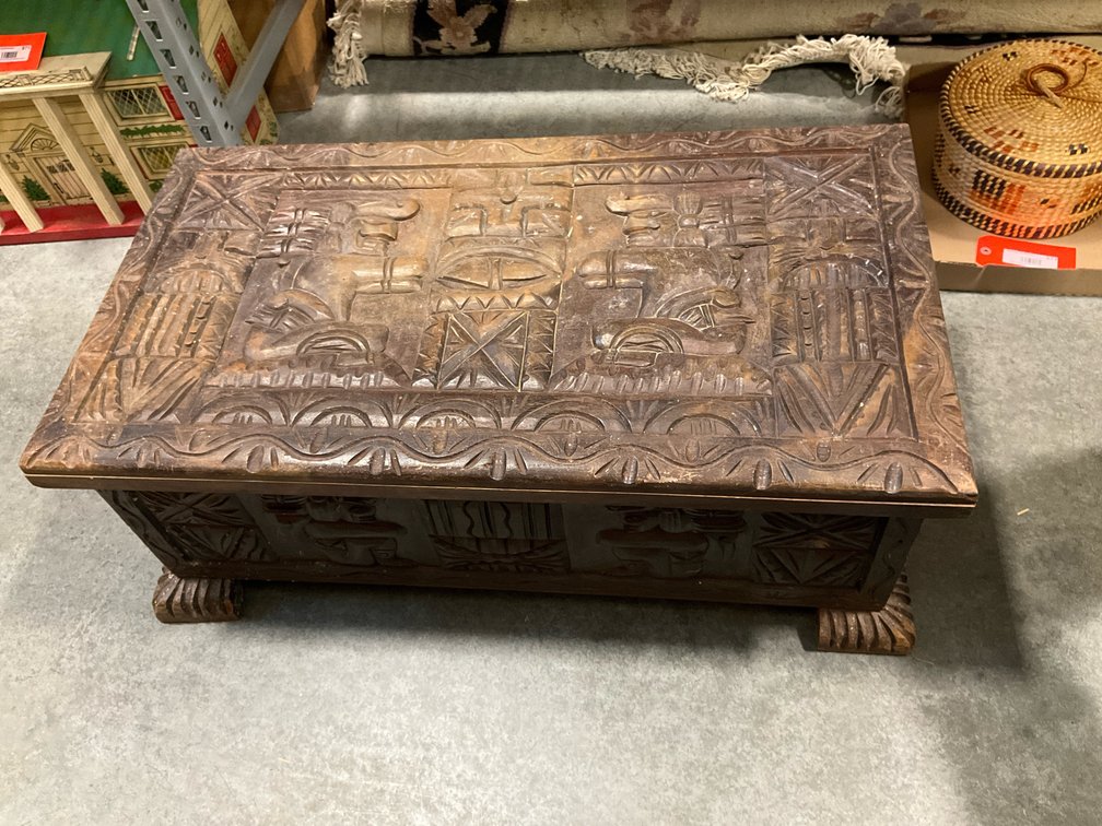 Carved dark wood chest with figural relief