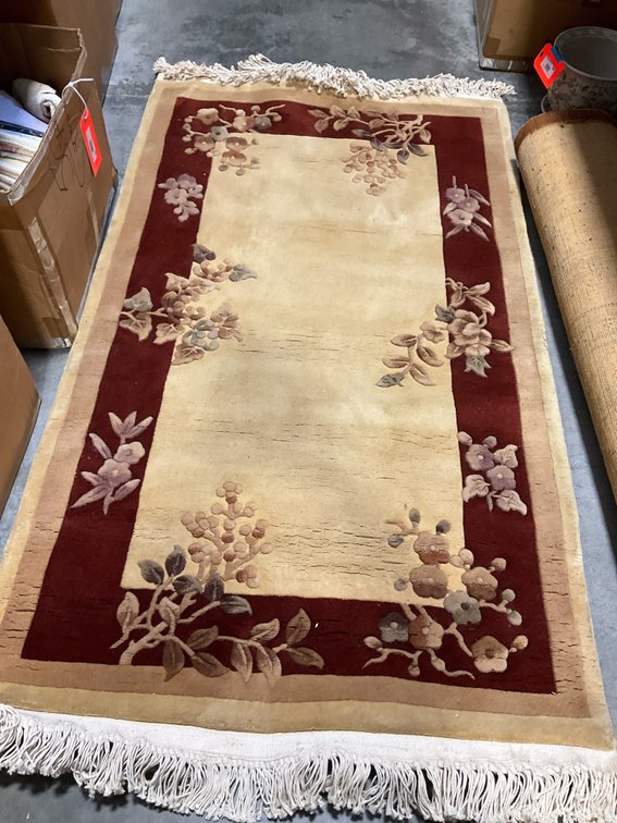 Cream and burgundy floral carved area rug with fringe