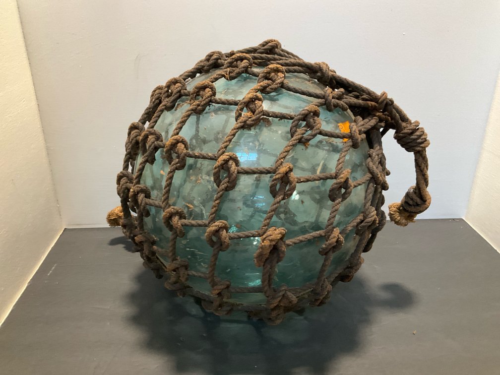 Aqua glass fishing float in knotted rope netting