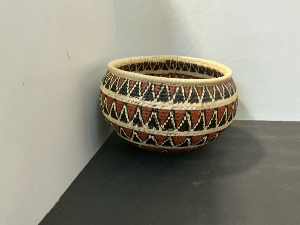 Coiled woven basket bowl with geometric starburst pattern
