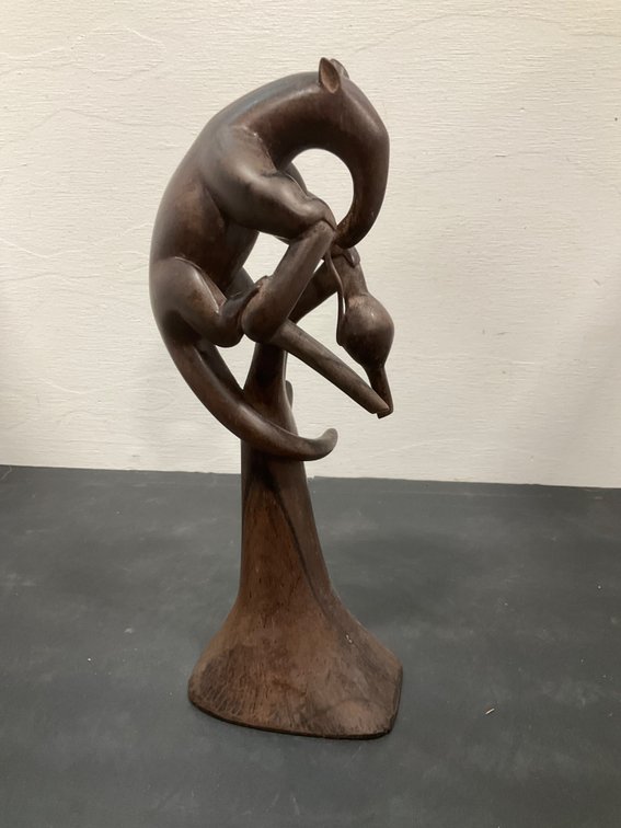 Carved dark wood animal on branch sculpture