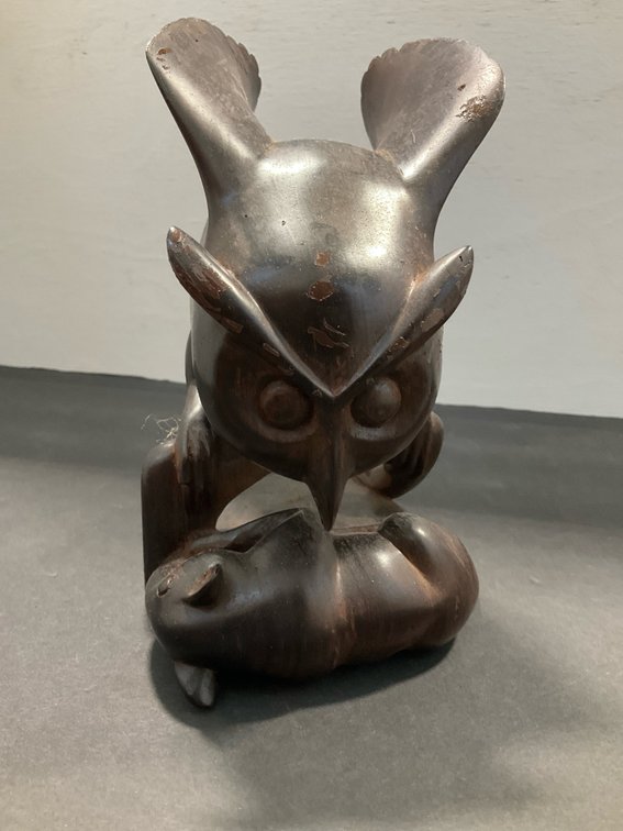 Carved wood owl sculpture with prey