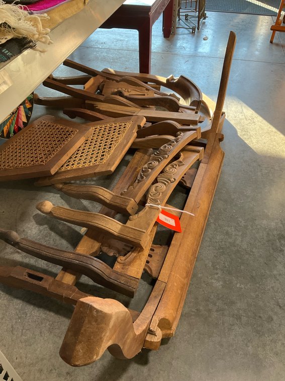 Disassembled carved wood chair parts with caned panels
