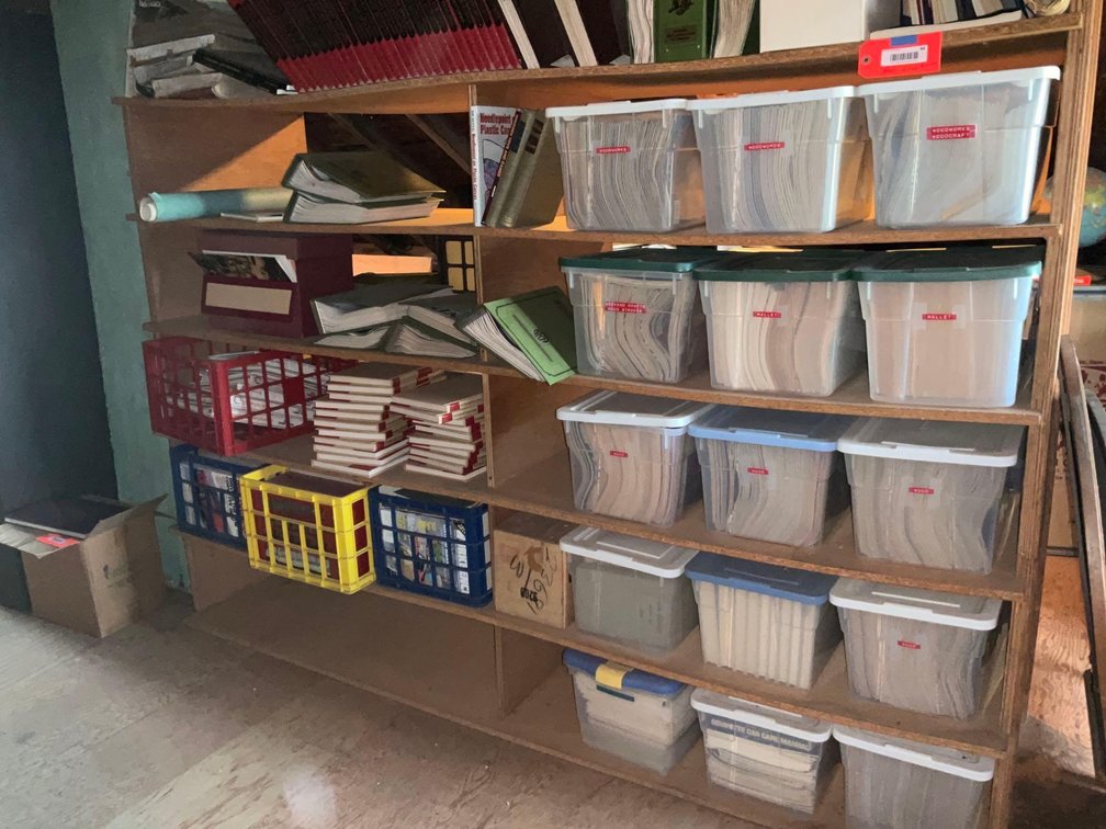 Small covered storage containers full of wood working related magazines-Attic 