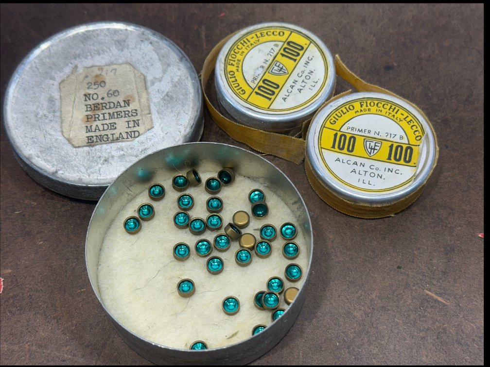 Three partial round tins of primers