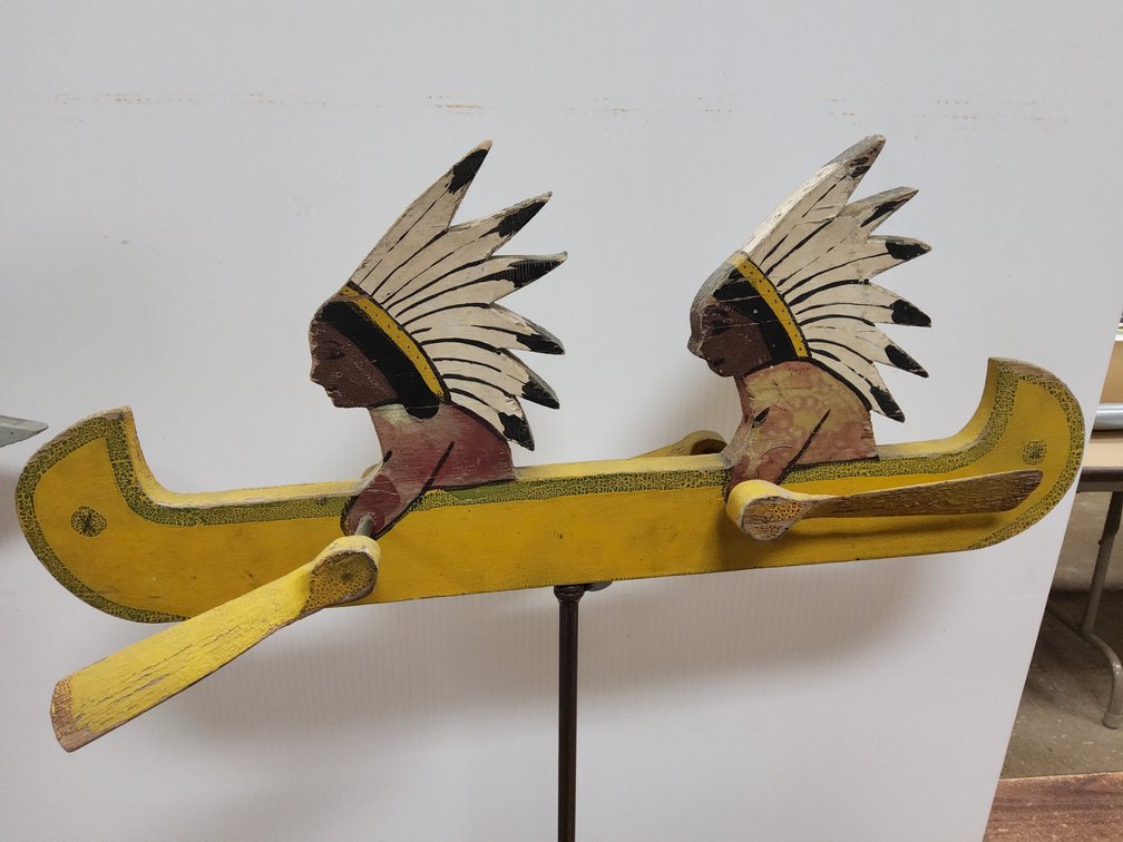 Whirligig of 2 Indians paddling a Canoe.
