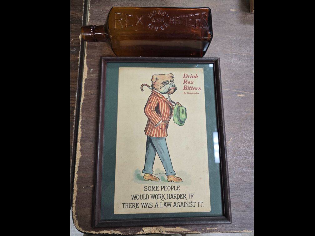Framed Rex Bitters advertising and a Rex Bottle