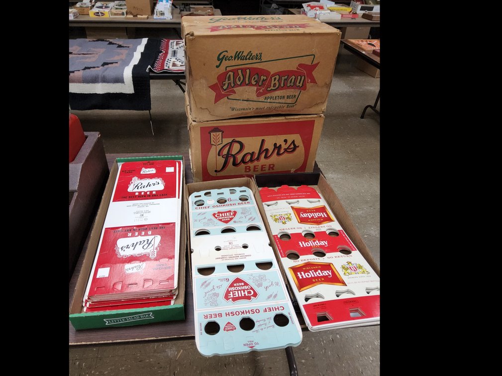 Assorted 6 pack beer carriers and empty cases of Rahr's & Adler Brau