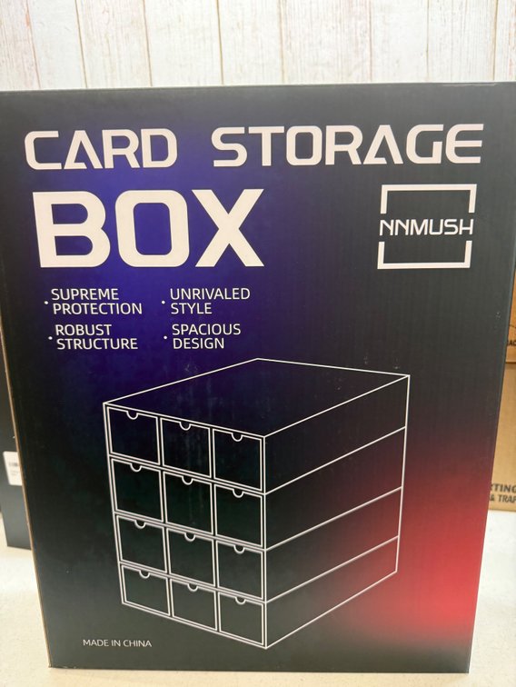 New NNMUSH card storage box. Has 12 drawers, 4 frames, 36 card dividers, 12 sponge card holders, 30 erasable labels, and a label marker. Great for organizing your trading cards.