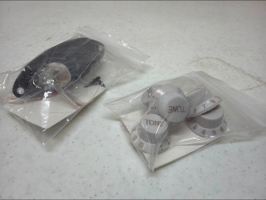 Black guitar pick up and white tone volume knobs