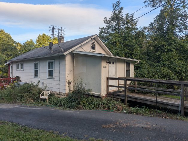 2 BR, 1 BATH BUNGALOW STYLE HOME W/ COVERED FRONT PORCH, HANDICAP ACCESS RAMP, & (2) OUTBUILDINGS ON 2.1 +/- AC LOT