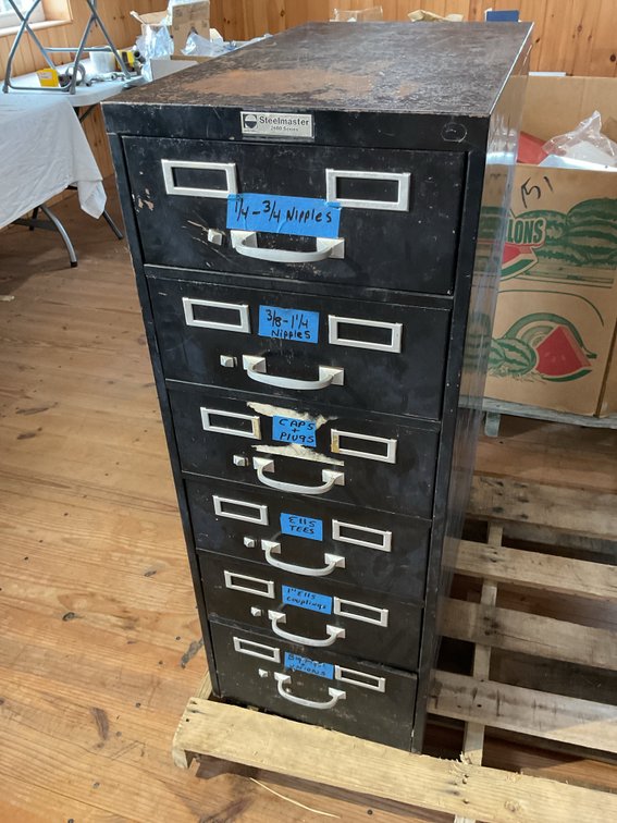 File cabinet loaded with black and galvanized pipe fittings