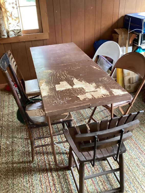 Old folding table with 2 folding chairs and 3 other chairs