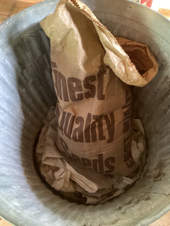 Big garbage bucket with partial bag of feed