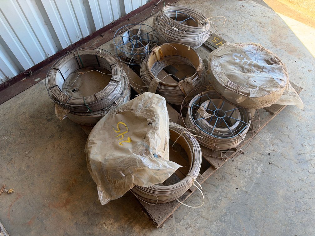 Metal Wire Coils and Spools on Wooden Pallet