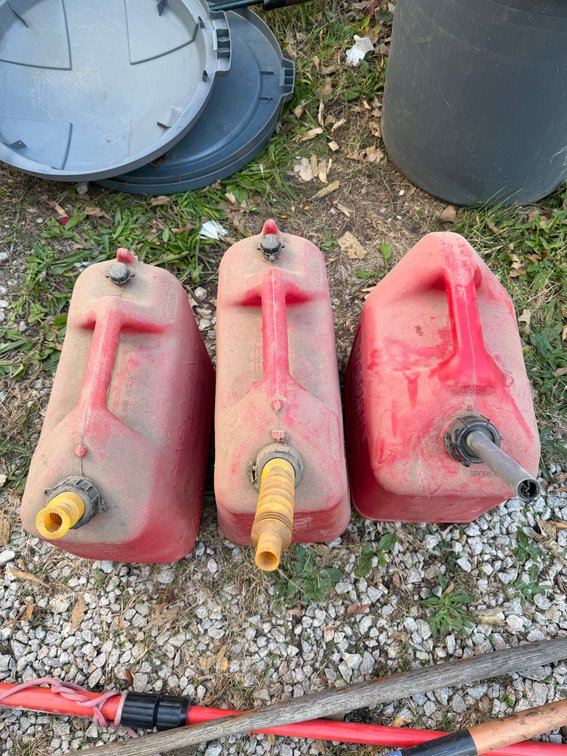 Three Red 5 gallon gas containers