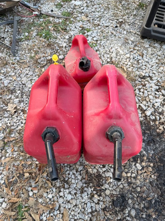 Two Red 5 gal and one 2 gal gas containers