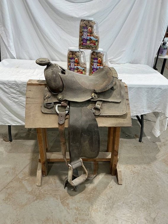 Western Style Leather Horse Saddle resting on a Saddle Stand including 3- Containers of Apple&Oat Horse Treats