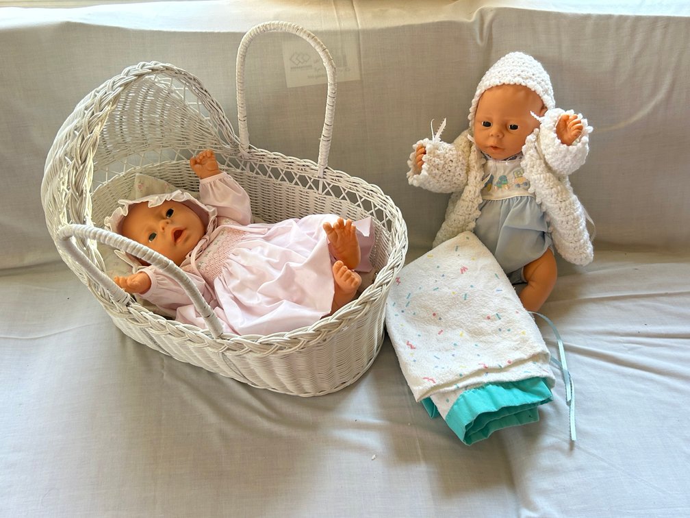 Two Vinyl Baby Dolls with Wicker Bassinet and Blankets