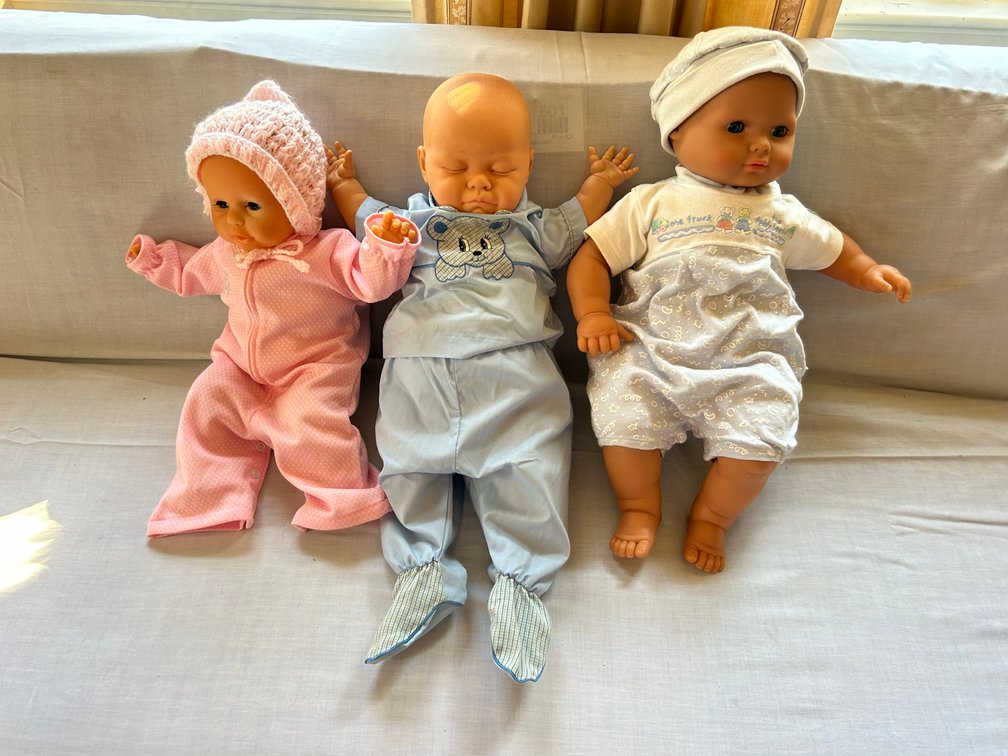 Three Vinyl Baby Dolls in Fabric Outfits
