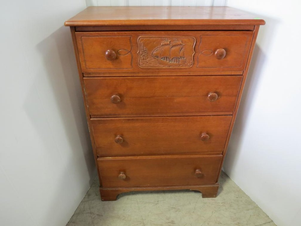 A four-drawer maple dresser by Emerson (New Hampshire) with a ship and castle carving on top drawer.