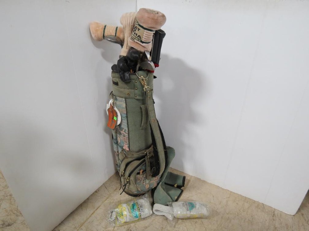 A collection of golf clubs including Callaway clubs and a vintage golf bag.